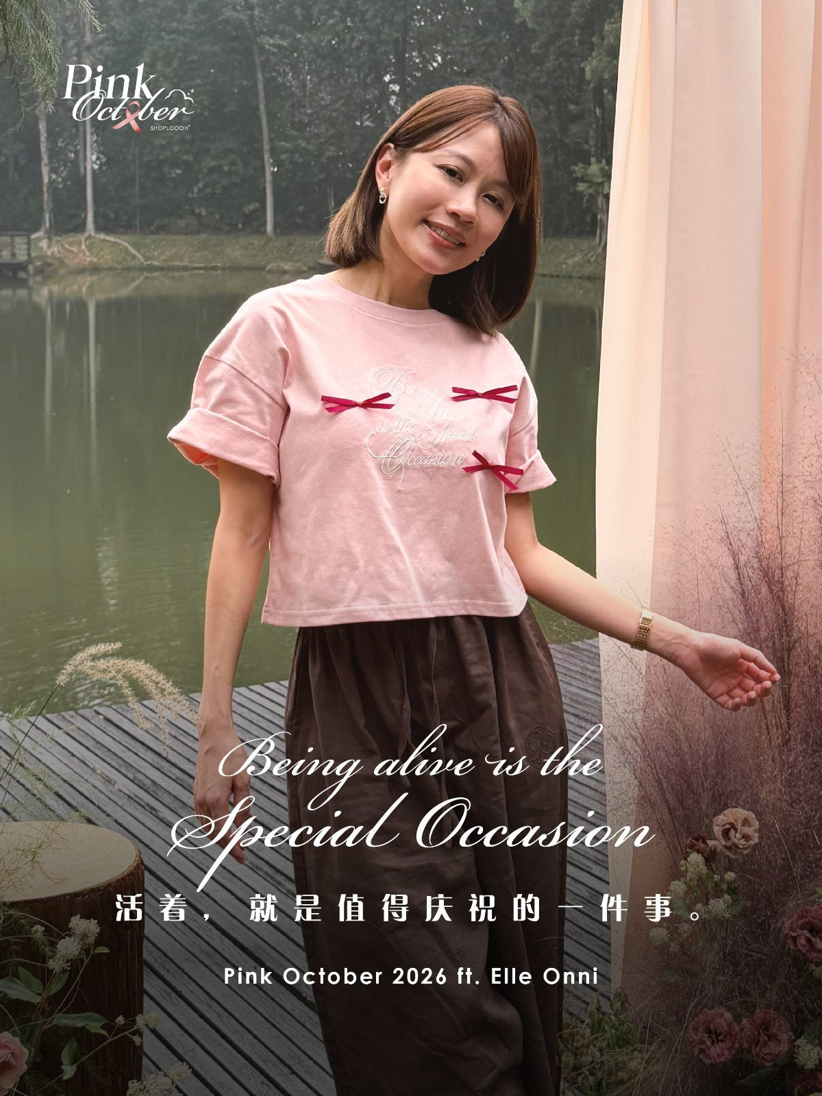 Elle Onni in the pink Being Alive Is the Special Occasion Tee by a lake — Pink October 2026 ft. Elle Onni
