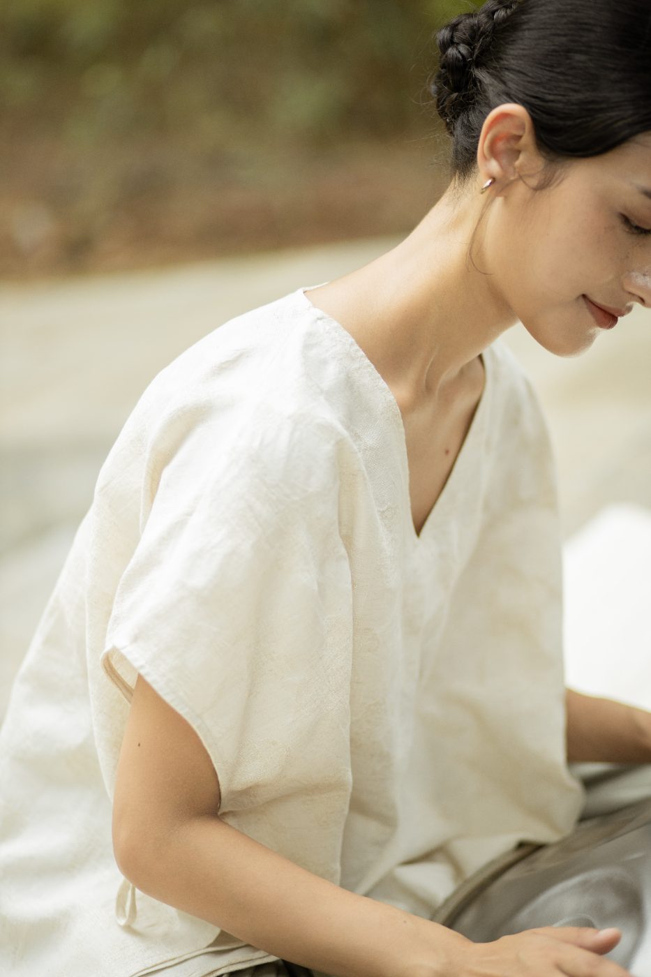 Close detail of the SHOPLOOOH Re Collection natural white V-neck top