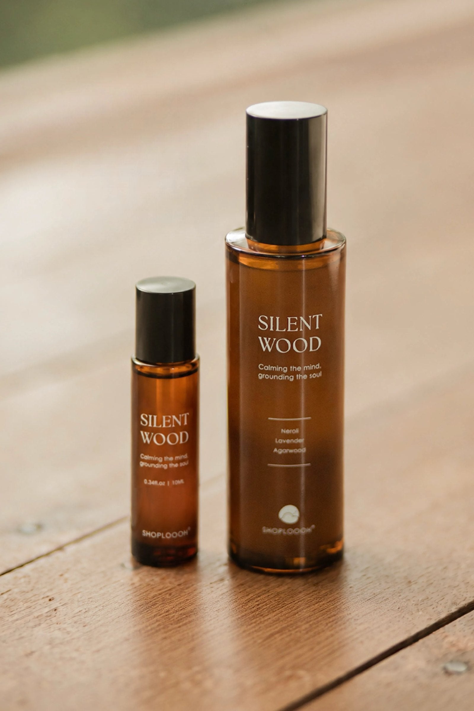 SHOPLOOOH Silent Wood essential oil roll-on and room spray on a sunlit wooden table